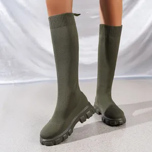 Primer plano de botas altas de punto verde oliva con una suela dentada muy gruesa