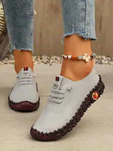 Detalle de los mocasines de cuero gris cosidos a mano con suela marrón muy flexible