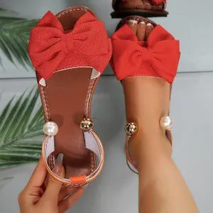 Red flat sandals for women featuring stylish bow and pearl accents, elegant open-toe design