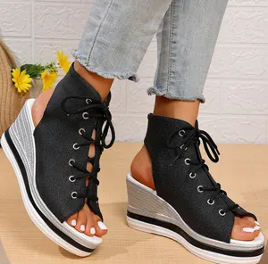 Detail of black lace-up wedge sandals with silver textured platform and peep toe.