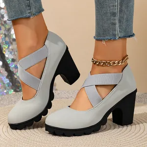 Detail view of light grey block heel pumps with elastic cross straps and scalloped sole