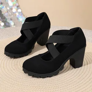 Detailed side view of black suede thick heel pumps with cross elastic straps