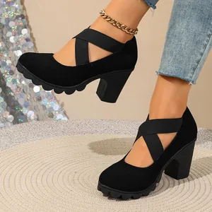Close-up of black chunky heel pumps with elastic cross straps and platform sole