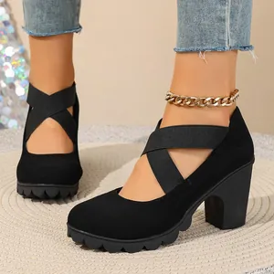 Elegant detail of black chunky heel pumps with elastic cross straps and thick platform sole