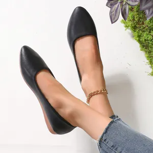 Side view of black pointed-toe flat shoes with textured leather finish