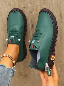 Primer plano de mocasines planos verdes cosidos a mano con suelas gruesas decorativas.