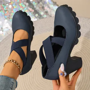 Close-up of navy blue platform pumps with elastic cross straps and chunky high heels