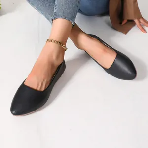 Detailed macro shot of elegant black pointed-toe flat shoes in premium textured leather