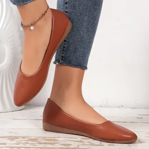 Detailed side view of stylish brown pointed-toe flats with pebble leather texture