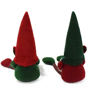 Back view of two plush Christmas gnomes with red and green hats on white background