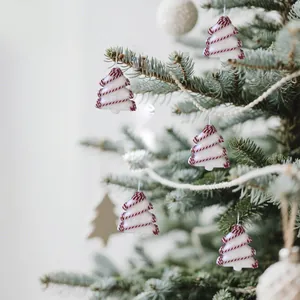 Primo piano di ornamenti natalizi in schiuma bianca decorativi appesi a un ramo
