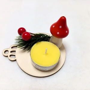 Detail view of a Christmas mushroom candle holder with a yellow tea light on wood
