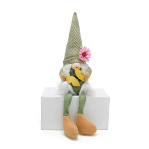 Close-up detail of a spring faceless gnome doll with pink flower and yellow butterfly decoration.