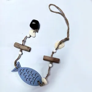 Detailed view of Mediterranean style wooden fish wall hanging with hemp rope and bell