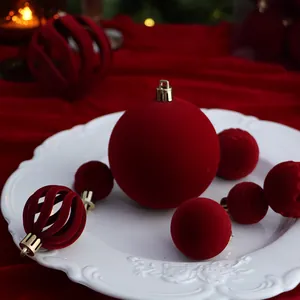 Luxury dark red flocked Christmas balls in various textures on an ornate white plate