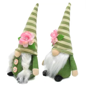 Detail view of two spring gnomes with green striped hats and pink peach blossoms