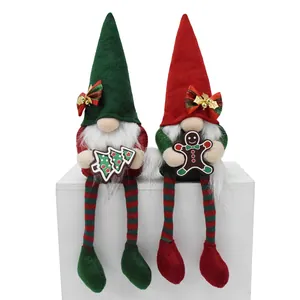 Pair of plush Christmas gnomes with gingerbread and tree accessories on a white box.