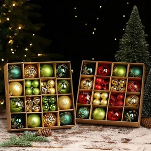 Detailansicht von 44 grünen, roten und goldenen Weihnachtskugeln in Boxen auf Schnee-Hintergrund