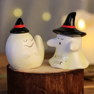 Pair of cute Halloween ghost resin figurines wearing witch hats on a wooden base