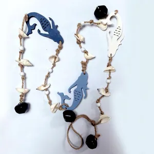 Detailed macro view of Mediterranean style wooden mermaid wall hanging with shells and bells