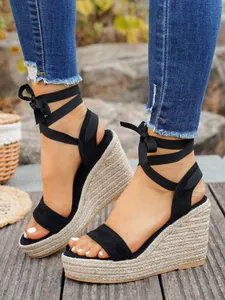 Black lace-up espadrille wedge sandals with a tall braided platform sole