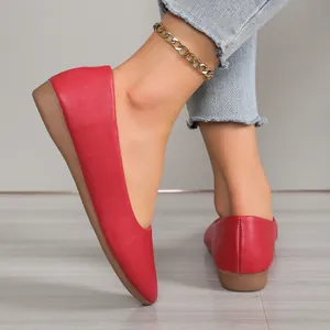Detailed view of red leather pointed-toe flat shoes featuring a stylish wedge heel
