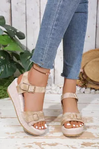 Detail of stylish beige wedge sandals with buckle straps and platform sole for summer.