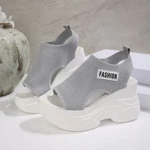 Detailopname van grijze ademende geweven platform sandalen met sleehak voor dames