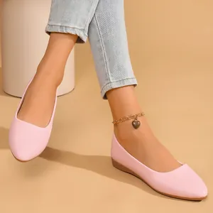 Close-up view of elegant pink pointed-toe flat shoes with soft textured material
