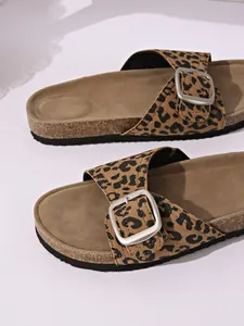 Close-up view of the leopard print pattern and adjustable silver buckle on stylish slide sandals.