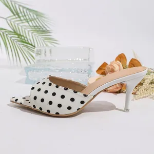 Elegantes mules blancos de tacón alto estilo francés con un patrón de lunares negros