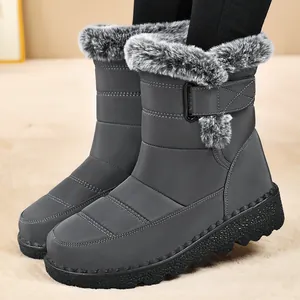 Detail view of dark grey snow boots with plush fur trim and textured soles