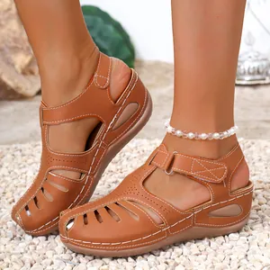Close-up of brown platform wedge sandals with contrast stitching and closed-toe design