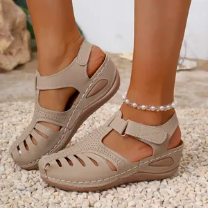 Close-up detail of beige wedge platform sandals featuring closed-toe design and stitching