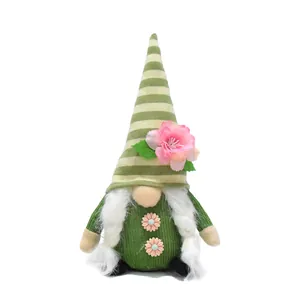 Close-up detail of handcrafted spring gnome with peach blossom and green striped hat