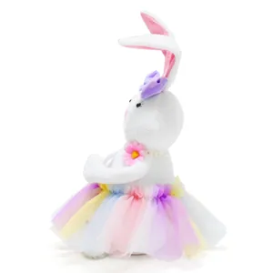Side view of a sweet white Easter plush bunny wearing a rainbow tutu and flower necklace