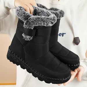 Detail of black waterproof snow boots with soft grey fur lining and velcro strap.