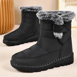 Close-up of stylish waterproof black snow boots with faux fur trim and velcro strap