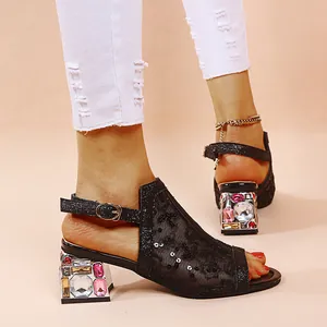 Detailansicht schwarzer Netz-Sandalen mit klobigem Absatz und bunten Strasssteinen