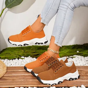 Detail view of vibrant orange and brown platform canvas sneakers in a lifestyle setting