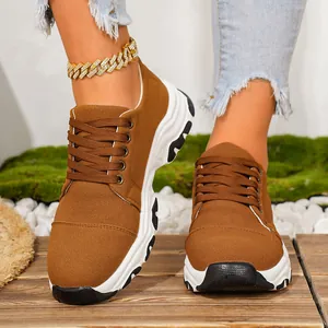 Detailed view of women's brown platform canvas sneakers with trendy color-block soles.
