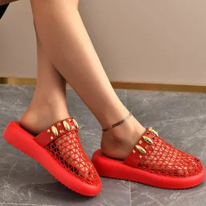 Close-up of stylish red mesh mule slippers with gold studs on a model's feet today