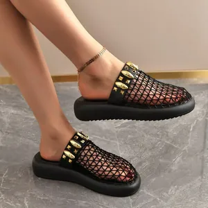 Detail of black mesh breathable mules with gold studs and a thick platform sole.