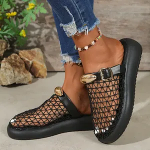 Detail view of black mesh platform slides featuring elegant gold buckle accents.