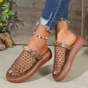 Close-up of stylish brown mesh closed-toe slippers featuring a decorative gold buckle