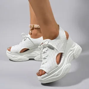 Κοντινό πλάνο από γυναικεία λευκά flyknit πέδιλα πλατφόρμας με κομψό σχέδιο peep-toe