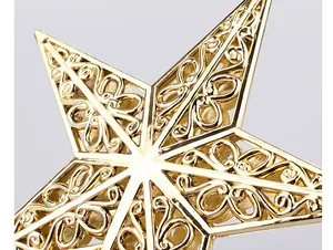 Macro detail of the golden hollow Christmas tree topper star featuring elegant scroll patterns
