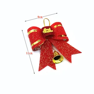 Detail view of red 3D Christmas bow ornament with gold bell and glitter, 11x9cm