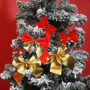 Detailansicht von kleinen roten und goldenen Weihnachtsschleifen an einem Tannenbaum.
