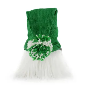 Close-up of the knitted texture and white fluffy beard of a green festive gnome doll